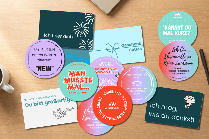 Verschiedene verNETZwerkt-Karten und runde Sticker mit kurzen Sprüchen rund um Ehrenamt und Wertschätzung liegen auf einem Tisch.