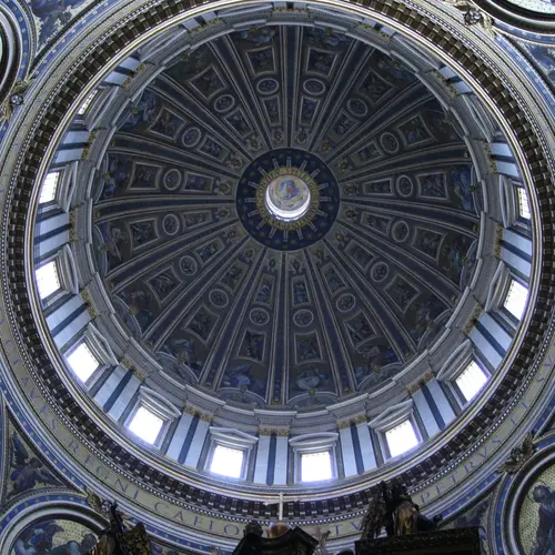 Das Bild zeigt die Kuppel des Petersdomes in Rom. Licht fällt durch die Fenster der Kuppel in den Kirchenraum.